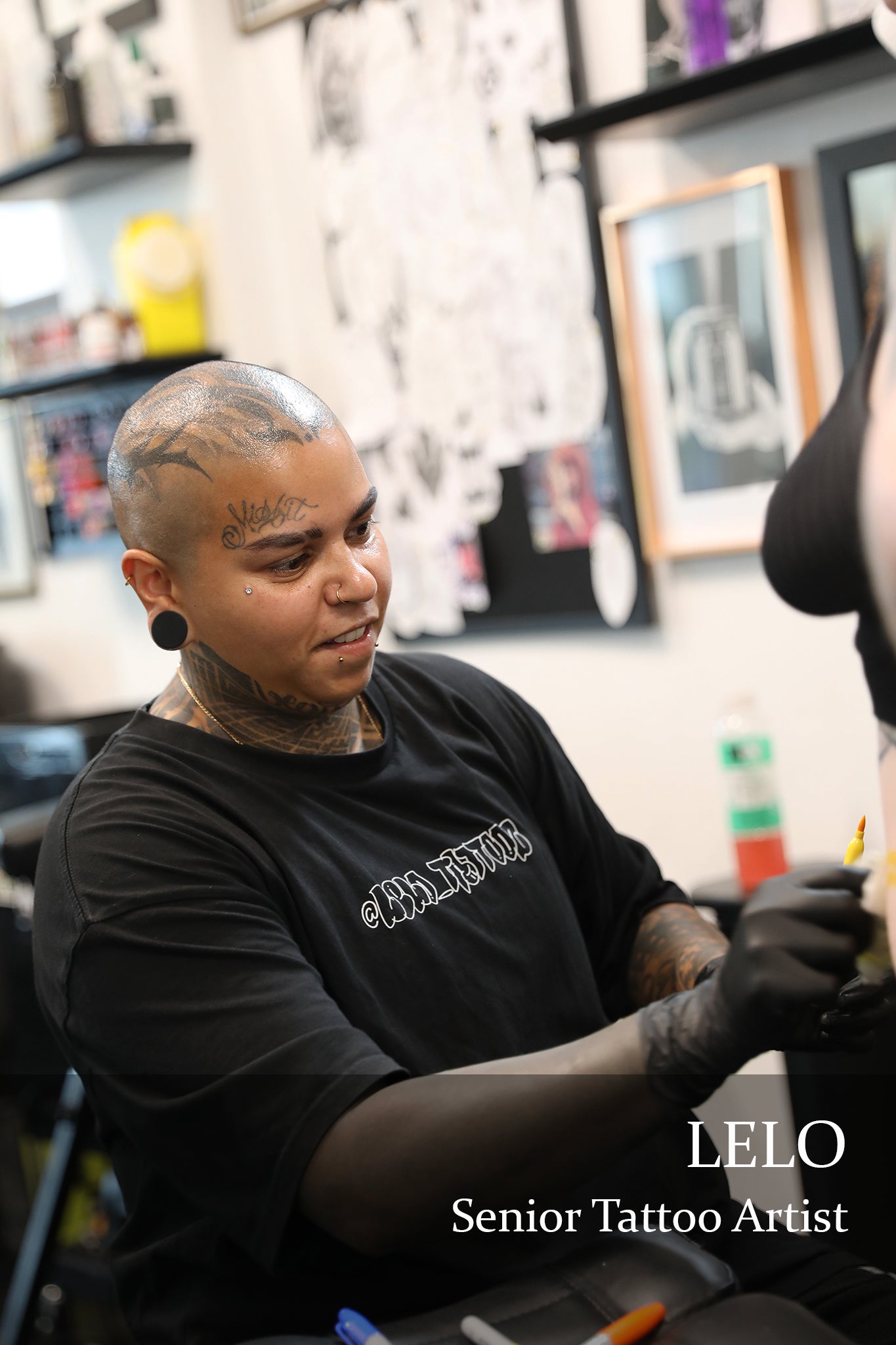 tattoo artist placing stencil on client