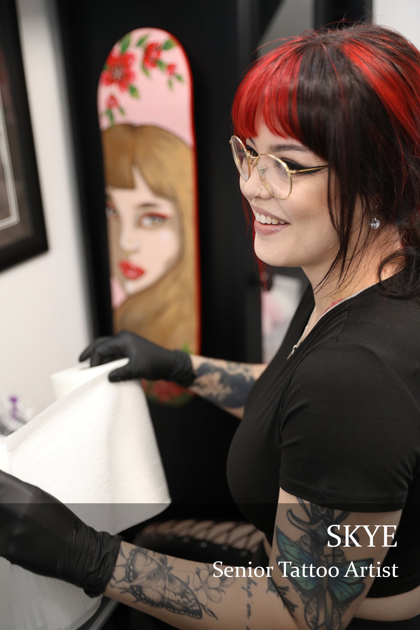 tattoo with black and red hair wearing black gloves