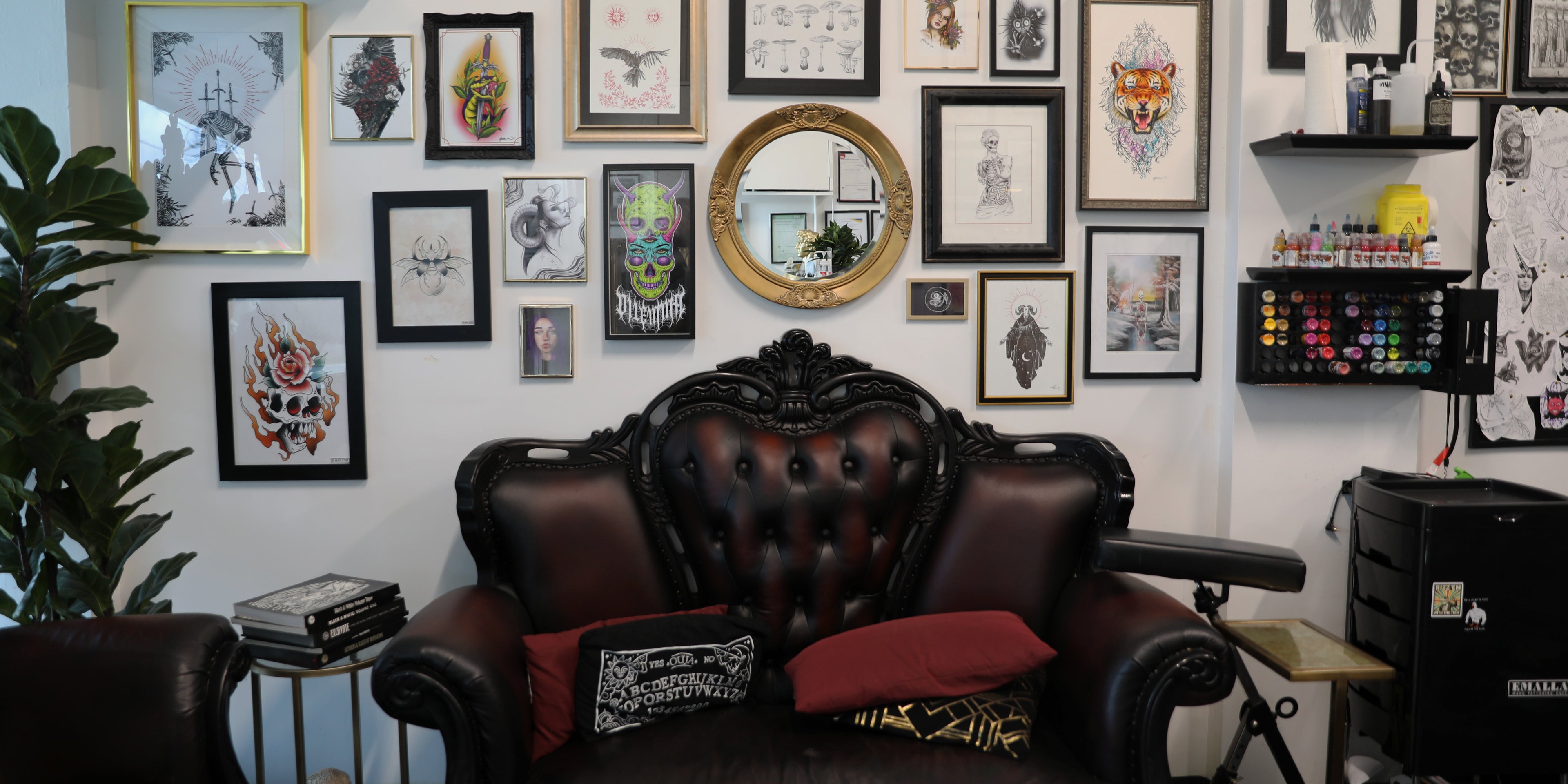 wall of art and tattoo ink with couch in front